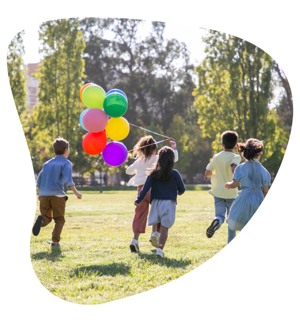 Kinder laufen mit bunten Luftballons über eine Wiese – Bildmotiv von Sonnenstrahlen
